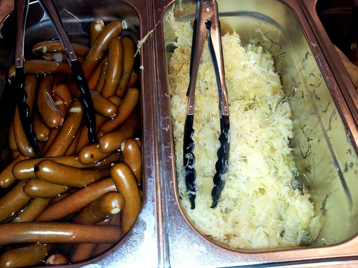 Best food sources for Vitamin K2, Tray of sausages next to tray of sauerkraut