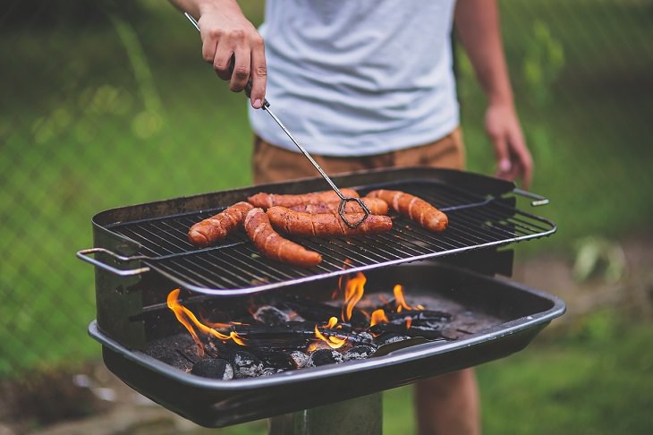 Best food sources for Vitamin K2, Man grilling sausages on a barbecue