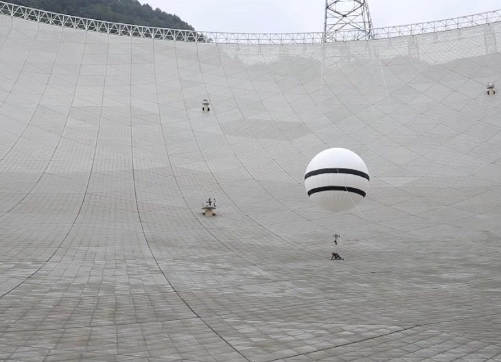 Amazing photographs of designs and manmade creations across the world, The maintenance crew of the FAST radio telescope’s fragile dish attach themselves to helium balloons to reduce their weight during their inspection