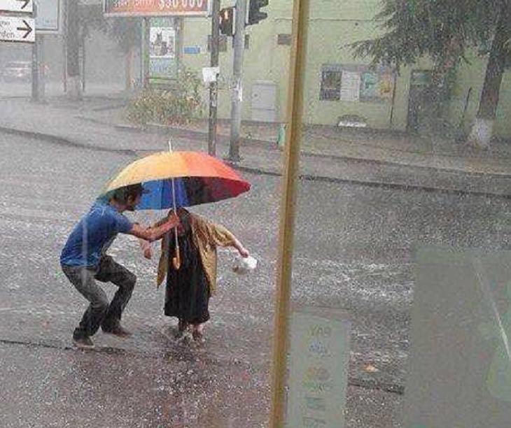 Beautiful pictures of touching, cute, and warm moments, Young man holding umbrella and helping old lady cross the road in the rain