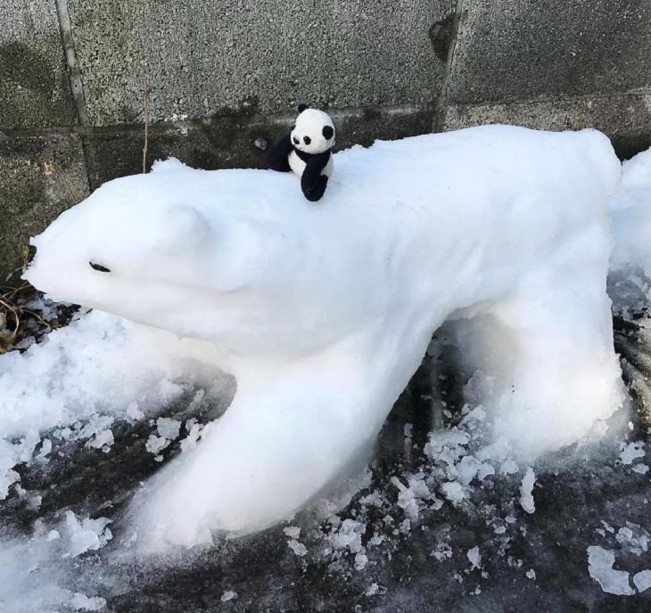 Residents of Tokyo create creative and unique snowmen and ice sculptures, Stuffed toy of panda bear sitting on snow sculpture of polar bear.