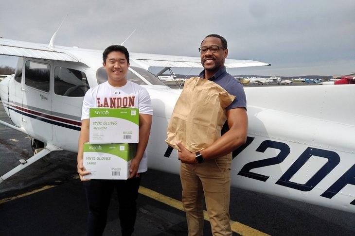 Best feel good stories of 2020, Teenager T.J Kim and flight instructor Dave Powell holding boxes of supplies donated to Page Memorial Hospital