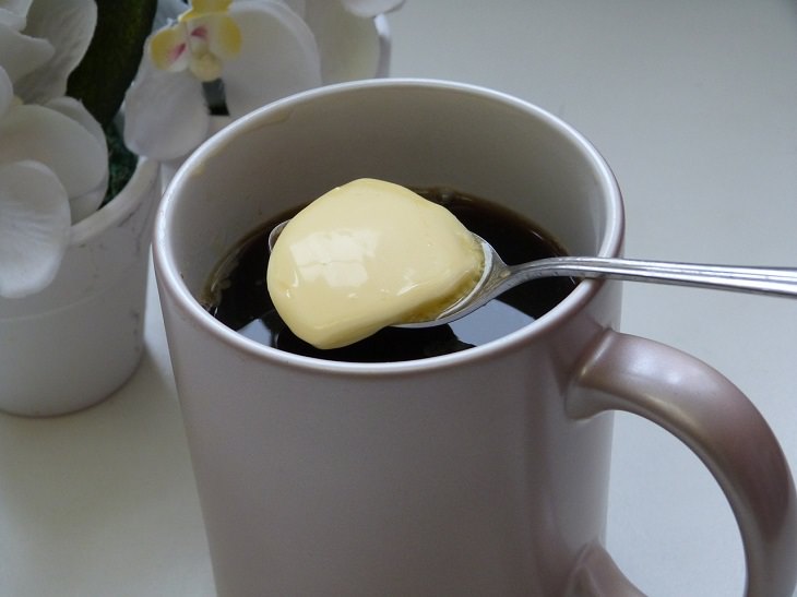 Drinks healthy to have while fasting, Cup of black coffee with a spoonful of butter over it