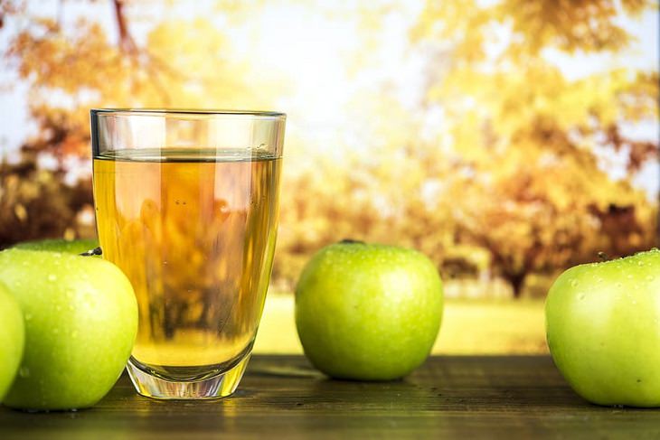 Drinks healthy to have while fasting, Apple next to a glass of apple cider vinegar or apple juice