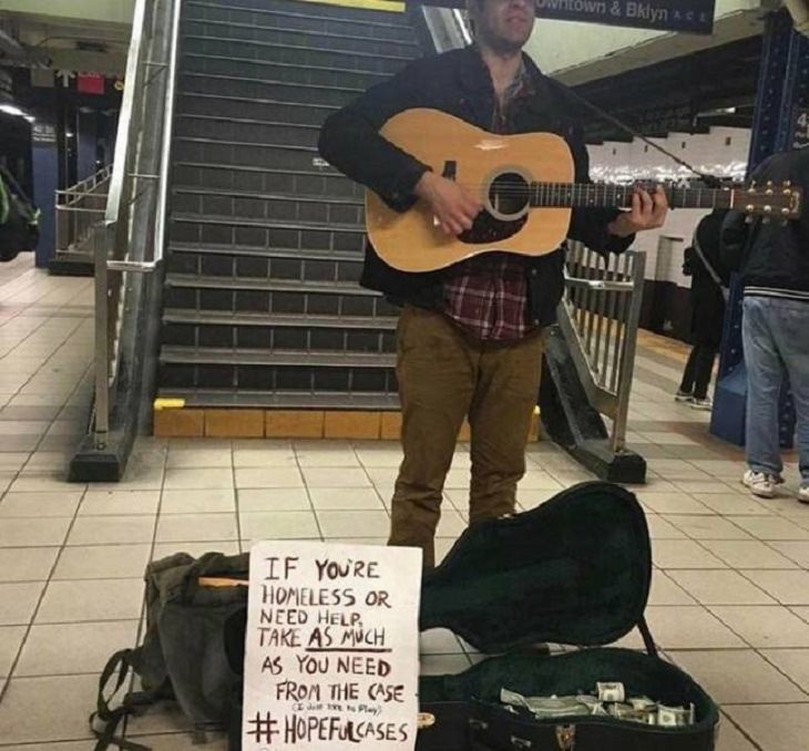 Photos of feel good stories that will make you smile, Street musician with a sign telling homeless people to take money from his case