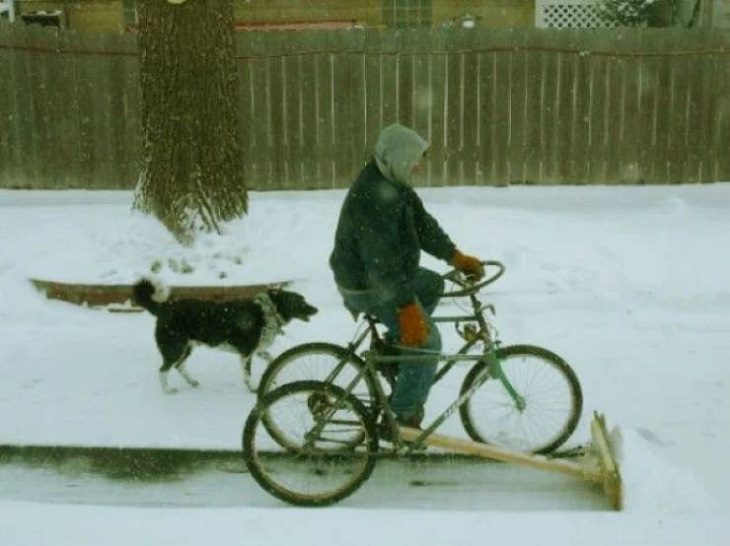 Makeshift, unique, and creative snowplows, Man on cycle with shovel in front of the cycle and dog walking beside