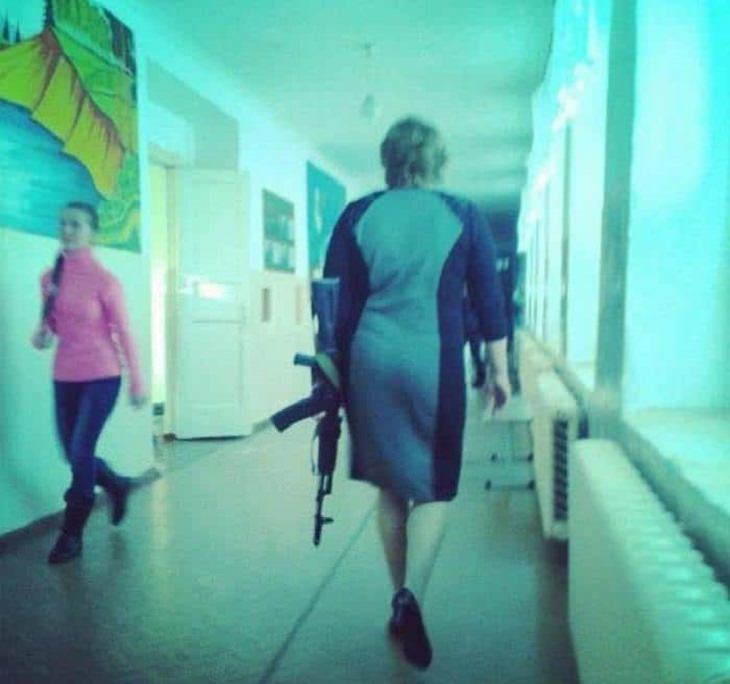 Strange, odd and weird things only found in Russia, woman in a school casually holding a large gun as she walks