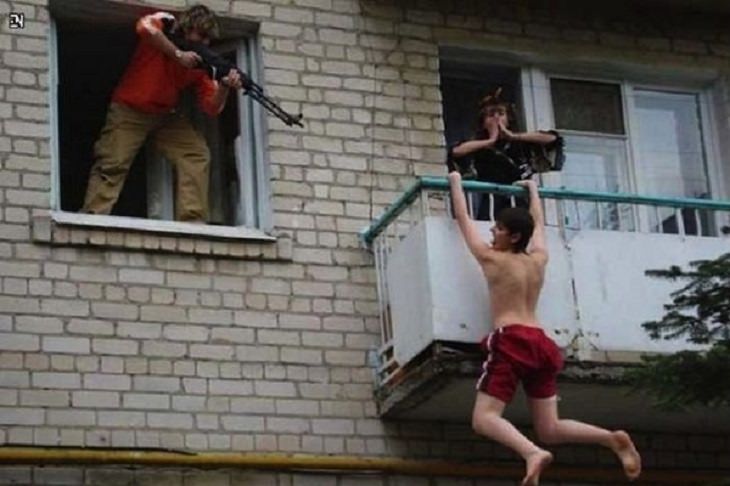Strange, odd and weird things only found in Russia, boy hanging off a ledge with guns on him