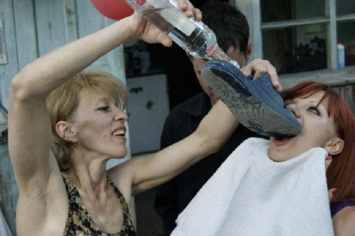 Strange, odd and weird things only found in Russia, woman pouring alcohol into another woman's mouth using a sandal