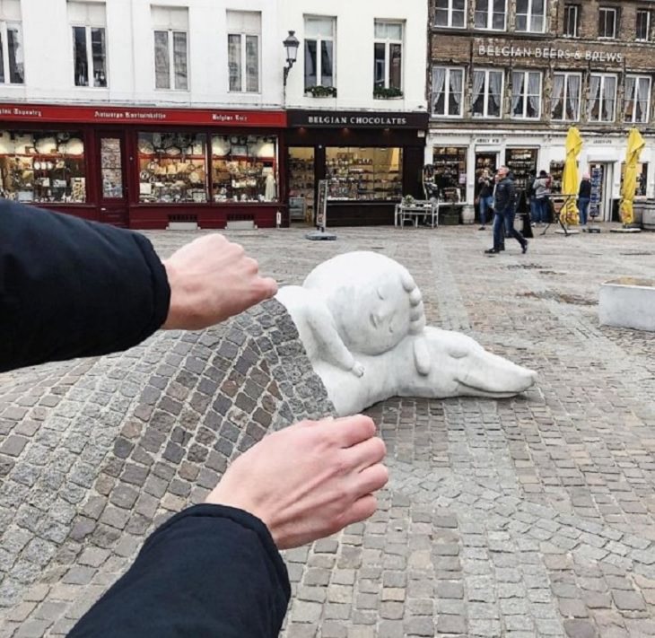 Incredible optical illusions created by Artist and photographer from Portugal Tiago Silva, person appears to be tucking in statue of child and dog