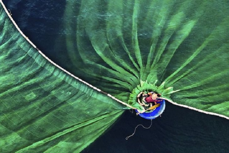 Winners of the Nature Conservancy World wide Photo Competition / Contest, People in Nature, People in Nature, First Place: Le Van Vinh, Vietnam DANCE IN THE SEA: A Fisherman casts a net, in Hon Yen, Phu Yen, Vietnam