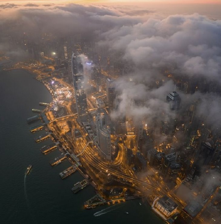 Winners of the Nature Conservancy World wide Photo Competition / Contest, Cities and Nature, Honorable Mention: Tsz Ho Tse, Hong Kong MORNING HONG KONG: Looking down at world famous Victoria Harbour through clouds early in the morning
