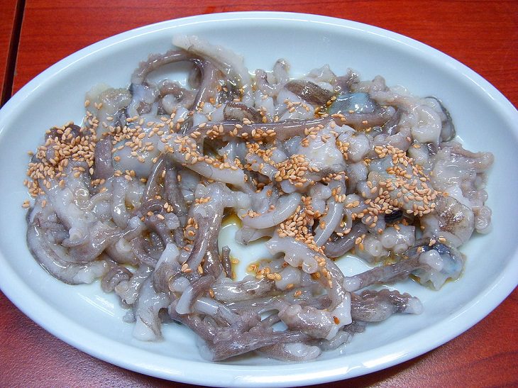Strange, weird, odd and unusual foods, recipes and ingredients from different countries around the world, San-nakji, a Korean dish made from a small octopus called sakji, served with toasted sesame seeds immediately after cutting, while the nervous system is still active