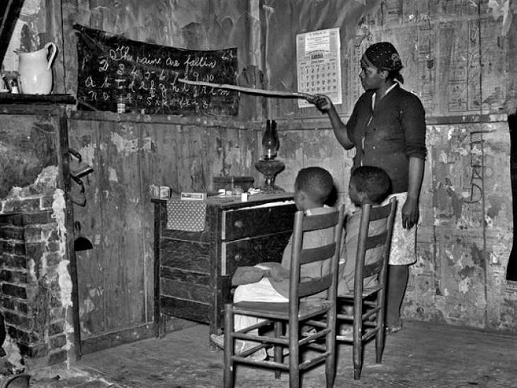 Historic photographs, An African-American sharecropper and devoted mother from Louisiana teaches her children letters and numbers at home in 1939