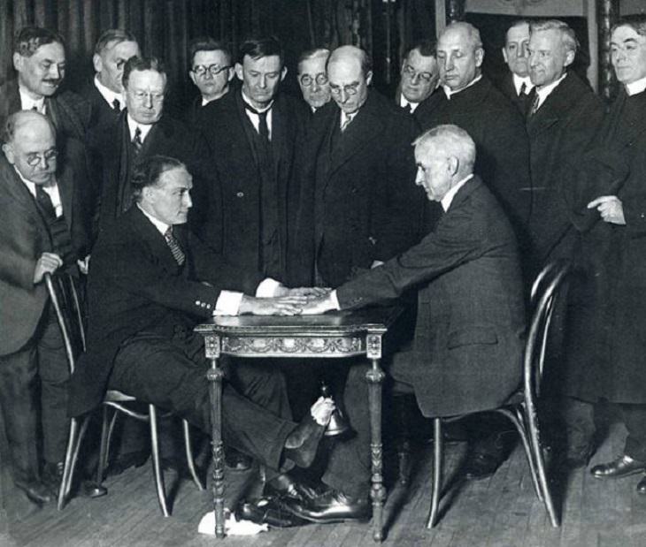 Incredible moments in historical captured on camera, important historical photographs, Harry Houdini, an illusionist who despised the false antics of claimed mystics, exposes the trickery behind talking to spirits to a New York clergymen in 1925