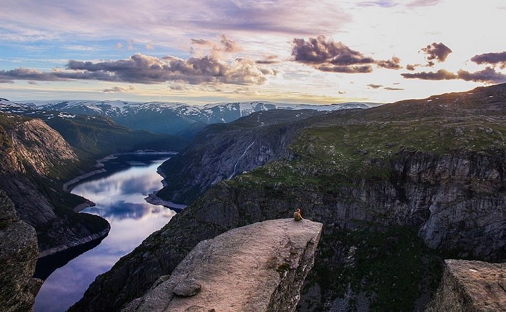 Sights from the popular hiking trail to the rock formation and cliff Trolltunga, near the town of Odda in Norway, On the peak of Trolltunga at sunset