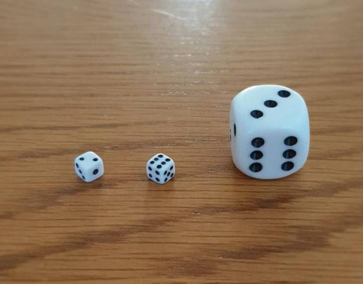 Photographs that show the size of objects and animals by comparison, Miniature dice next to a normal pair of dice