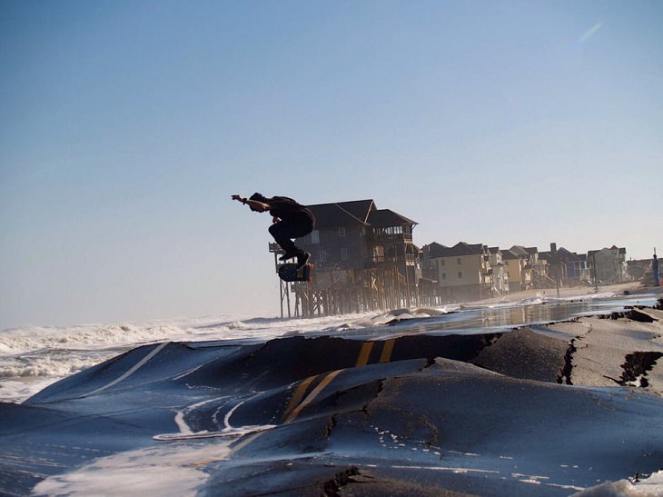 Photos showing the power and aftermath of natural disasters, skater riding skateboard over broken roads on the outer banks of North Carolina after Hurricane Sandy