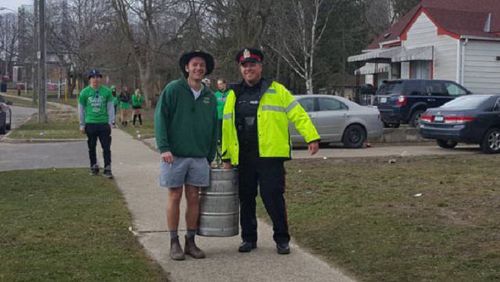 Hilarious pictures that could only be taken in Canada, officer with civilian carrying a beer keg