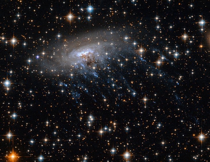 Photo gallery of the most unusual and strangely beautiful galaxies found in the universe and across space, Galaxy ESO 137-001, which is stripped by hot gas as it moves, creating a trail that gives it a jellyfish-like appearance
