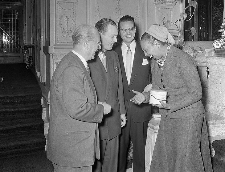 Josephine Baker: Siren of the Resistance, Josephine Baker laughing and shaking hands with 3 men in suits