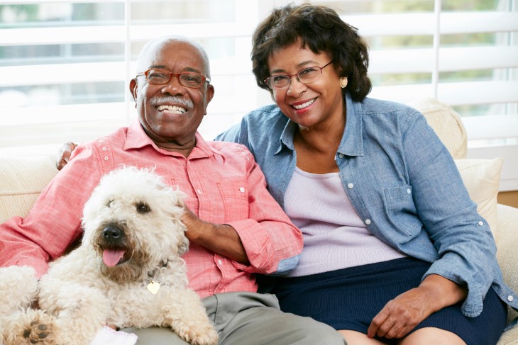 casal de afrodescendentes sorrindo e com cachorro