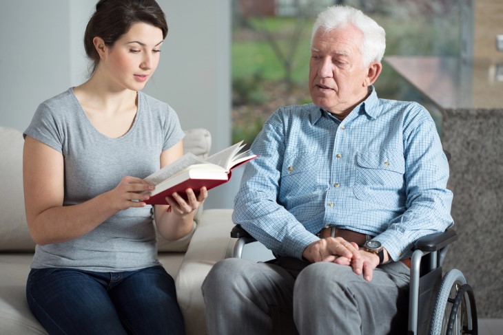 mulher lendo para homem idoso