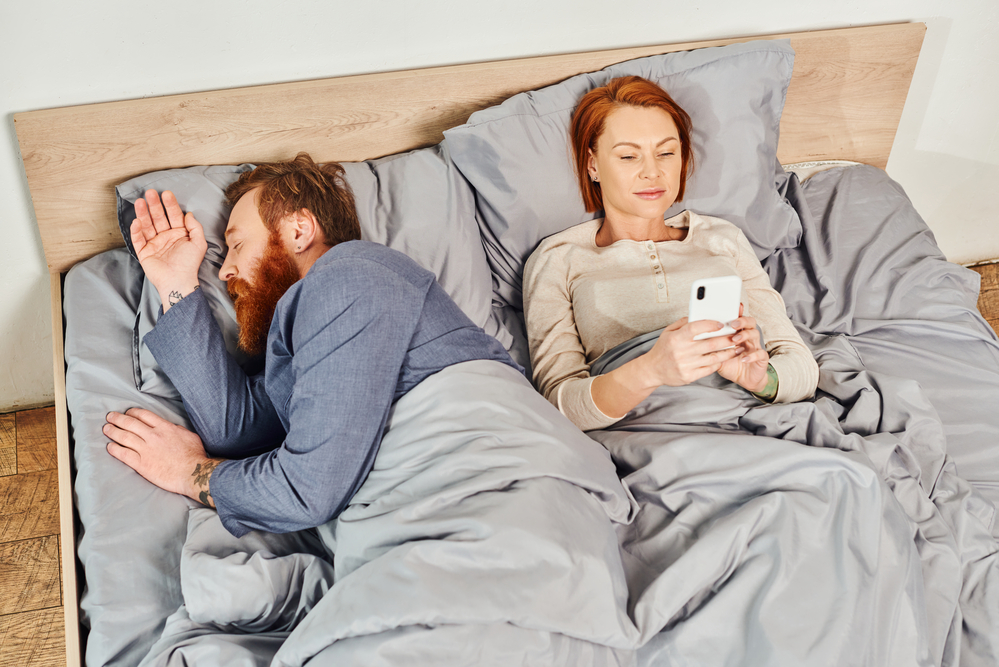 woman using smartphone in bed