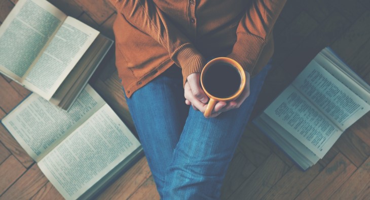 woman with coffee and 3 books