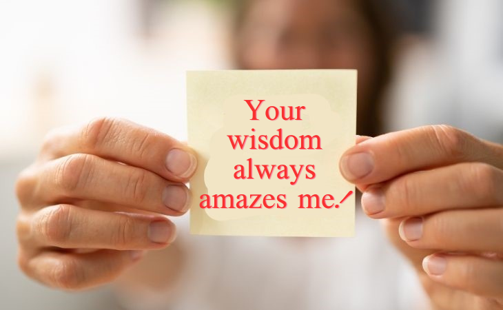 How to compliment your partner: A woman holding a note that says 'Your wisdom always amazes me'