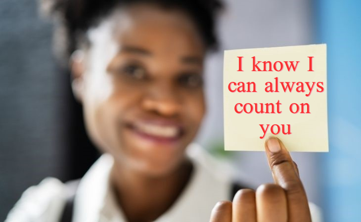 How to compliment your partner: A woman holding a note that says 'I know I can always rely on you'