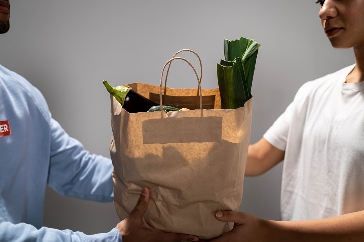 Coping with a sick spouse: A woman receiving a grocery delivery bag