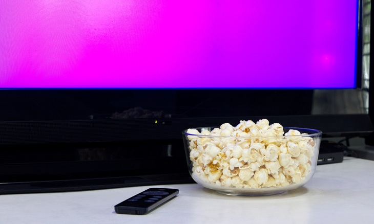 Foods to avoid giving children: A bowl of popcorn against a TV screen background