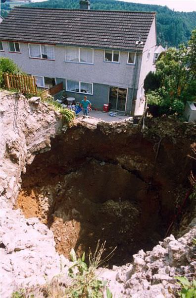 a Giant sink hole next to man's house