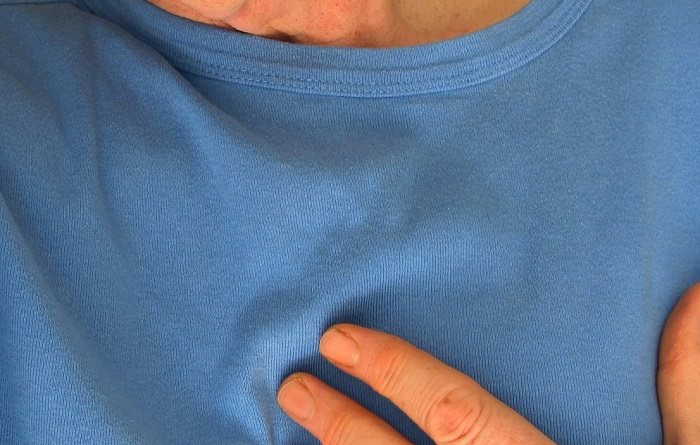 Household Injuries: man touching chest in pain with blue shirt