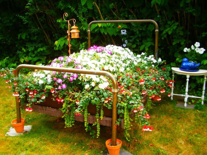 Recycled Furniture 4 post bed used to grow plants on as part of garden 