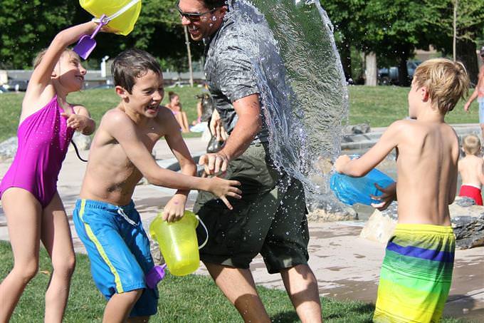 man and kids having a water fight