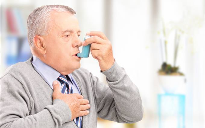 elderly man using asthma inhaler