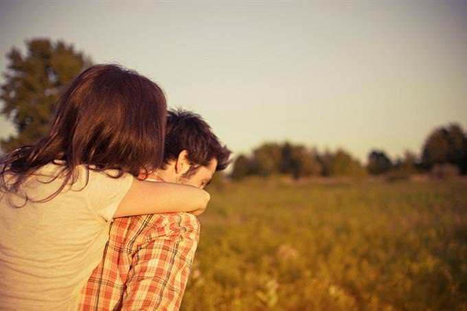 a coup hugging facing a field