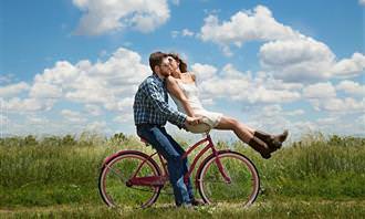 couple riding a bike and kissing
