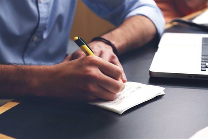 man writing a note