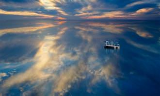 an ocean with clouds reflected in it