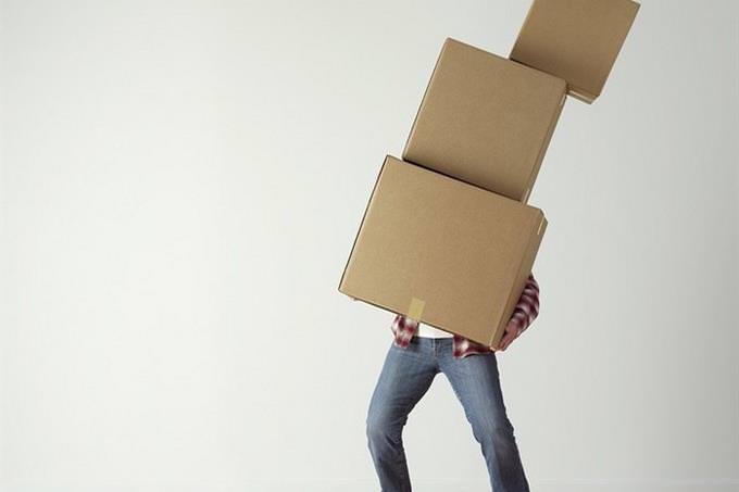 man hidden behind a tall pile of boxes