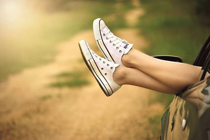 womens legs hanging out of a car window