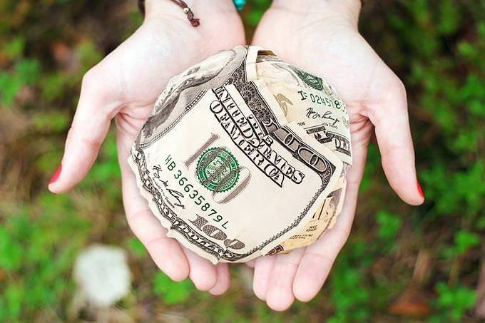 a woman's palms holding a wad of cash