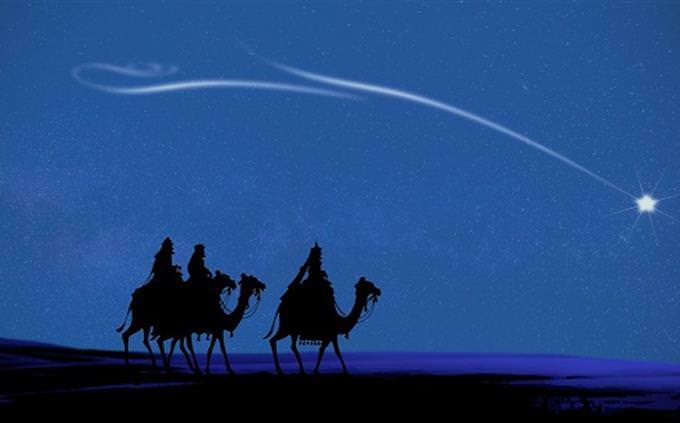 A star in the sky above a convoy of camels