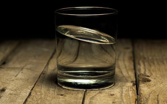 A glass of water on a wood table