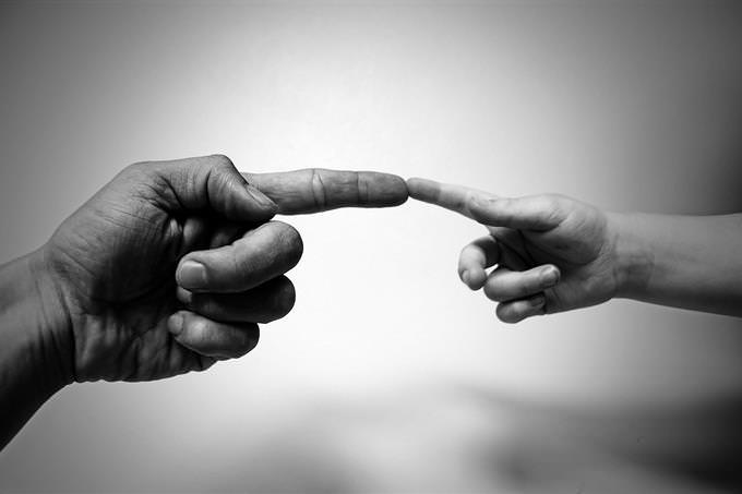 a man and child's hands meeting