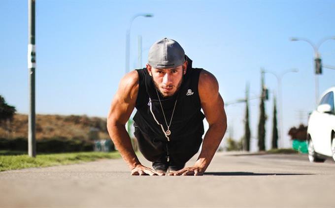 Man doing push ups on a boardwalk