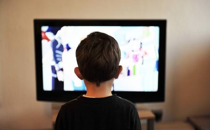 A boy sitting in front of a t.v